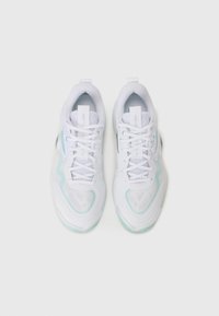 Baskets blanches de sport avec une tige en mesh, accents menthe subtils, bout arrondi et semelle texturée. Les lacets passent à travers des œillets renforcés.
