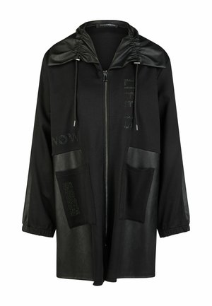 Schwarze lange Zip-up-Jacke mit großen Fronttaschen, Kordelzugkapuze mit lederartigem Besatz und dezenten Textdetails auf Brust und Tasche.