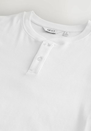 Valge ribaga henley särk, millel on ümmargune kaelus ja kolm nuppu lipiku peal. Brändi silt "NEXT" sisekaelusel.