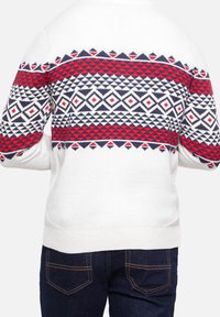 Suéter de punto blanco con un patrón geométrico en rojo y azul marino. El diseño incluye diamantes y flechas en la parte posterior. Corte clásico.