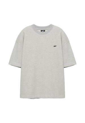 Hellgraues T-Shirt mit kurzen Ärmeln und Rundhalsausschnitt, mit kleinem schwarzem Logo auf der linken Brust, flach auf weißem Hintergrund präsentiert.