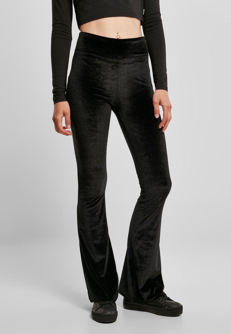 Leggings évasés en velours noir avec une taille haute. Texture douce et finition lisse, conçus pour épouser parfaitement la taille jusqu'aux genoux.