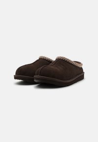 Sabots en cuir suédé marron avec un dessus texturé, une bordure tissée et une semelle en caoutchouc plate. Le design est à enfiler, avec un bout arrondi et un style minimaliste.