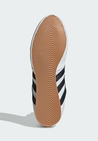 White athletic shoe sole with a textured brown rubber bottom, featuring three black stripes along the side for grip and stability.