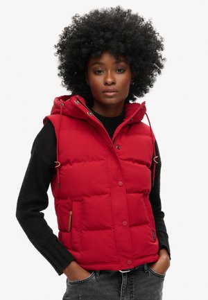 Rode gewatteerde vest met een capuchon, voorzien van een knoop- en ritssluiting, twee voorzakken en verstelbare koorden voor een comfortabele fit.