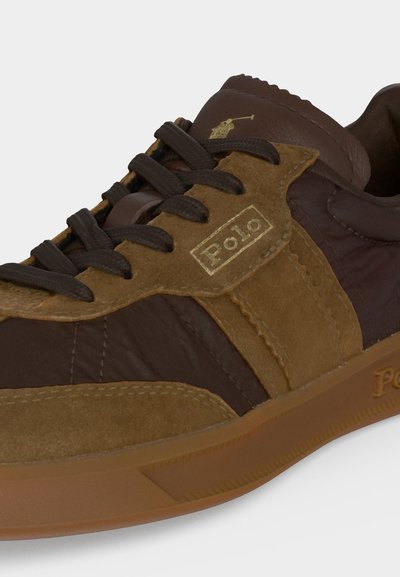 Καφέ και ταμπά sneaker από δέρμα και σουέντ με σκούρα καφέ κορδόνια, λογότυπο Polo στο πλάι και στη γλώσσα και σόλα από καουτσούκ.