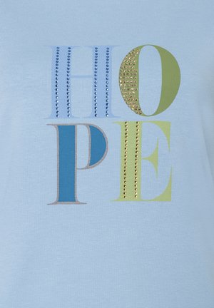 Blauer Stoff mit dem Wort HOPE in großen Blockbuchstaben; Buchstaben sind mit blauen und goldenen Nieten verziert, um zusätzliche Textur zu verleihen.