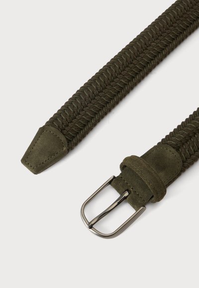 Ceinture en tissu vert foncé tressé avec embout et boucle en daim, avec une boucle en métal argenté sur un fond clair uni.