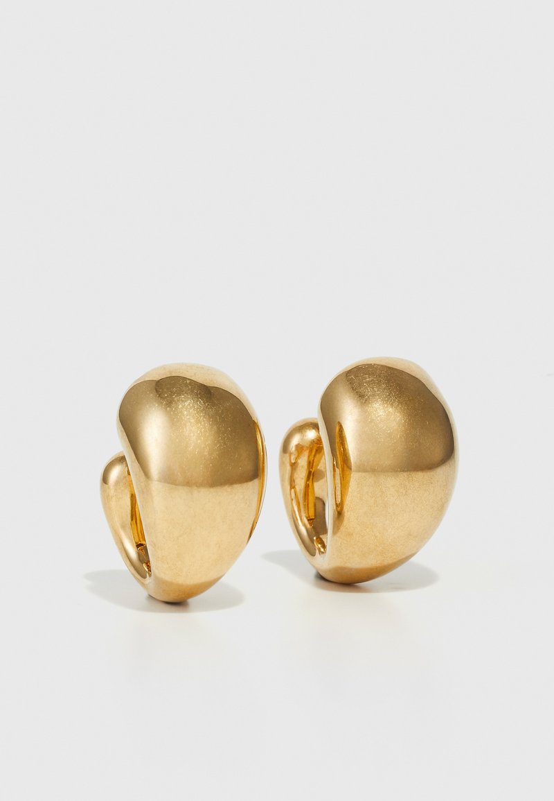 Boucles d'oreilles dorées avec un design lisse et arrondi, et une finition polie. Présente un style à clip pour un port facile.