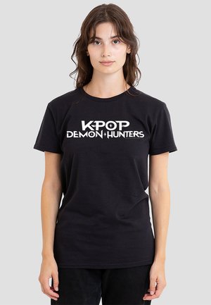 Schwarzes Baumwoll-T-Shirt mit weißem Grafiktext "K-POP DEMON HUNTERS" in verschiedenen Schriftarten. Kurze Ärmel, klassisches Rundhals-Design.