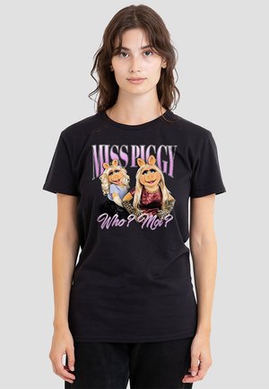 Schwarzes Baumwoll-T-Shirt mit den Cartoonfiguren Miss Piggy und einer blonden Figur. Auf der Vorderseite steht in lila und weiß der Text "MISS PIGGY Wer? Moi?"