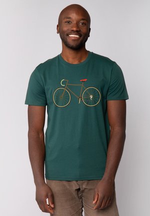 Groene t-shirt van katoen, met een fietsafbeelding in bruin en een rode zitting. Korte mouwen en een ronde halslijn.