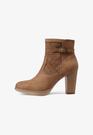 Stivaletto alla caviglia in camoscio color tabacco con tacco a blocco impilato, motivo floreale laserato e cinturino decorativo con fibbia su sfondo bianco.