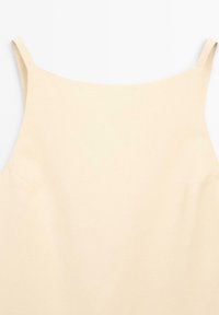 Beige tanktop met dunne schouderbandjes en een gladde, matte textuur. Eenvoudig ontwerp zonder zichtbare patronen of hardware.