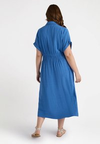 Abito blu, al ginocchio, a maniche corte con vita elastica. Realizzato in tessuto leggero, presenta un colletto e risvolti sui polsini.