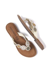 Perleflip-flop sandaler med en lys cremefarvet rem, cirkulære perleaccentuer i guld, sort og hvid, samt en brun ruskindsfodbed.