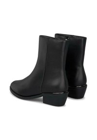 Botas de tobillo de cuero negro con punta redonda, tacón bajo y una acentuación plateada en el tacón. Presentan un cierre con cremallera en la parte posterior.