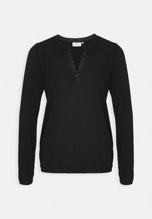 Blouse noire à manches longues avec un col en V bordé de satin et un ourlet élastiqué.