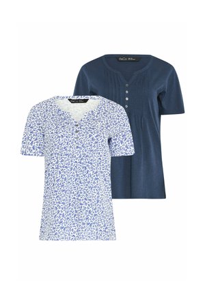 Twee dames tops met korte mouwen; één effen marineblauw met knopen en plooien, één wit met een blauw bladpatroon en knopen aan de voorkant.
