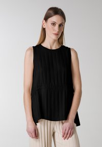 Zwarte mouwloze top met verticale plooien, ronde halslijn en geraffineerde taille-detail, met een ontspannen silhouet.