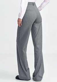 Szare spodnie w prążek z wysokim stanem, szerokimi nogawkami i gładką teksturą, z dwiema tylnymi kieszeniami i starannym wykończeniem szwów.