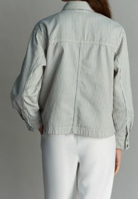 Gestreept, lichtgewicht overhemd in lichtblauw en wit met lange mouwen en knoopmanchetten, voorzien van een achterkant met inzetstuk en een losse pasvorm.