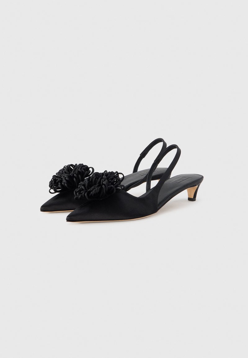 Sorte sko i satin med slingback, spidse tæer og lille hæl, med teksturerede blomsterdetaljer foran. Enkel, elegant design.