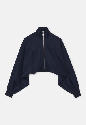 Marineblå kort jakke med glidelås laget av glatt stoff, med høy krage, senkede skuldre og diskret logo detaljer på brystet.