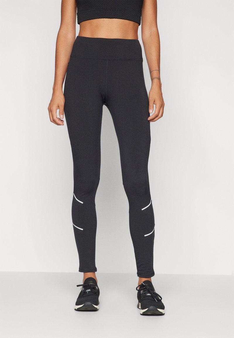 Leggings de sport noirs avec une taille haute et des bandes réfléchissantes blanches sur les côtés, fabriqués en tissu extensible et évacuant l'humidité.