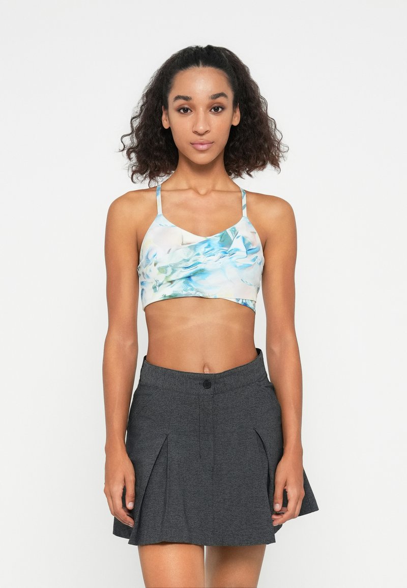 Világoskék és zöld virágmintás crop top vékony pántokkal, szürke, harangszoknyával párosítva, amely gomb- és redőmintázattal rendelkezik.
