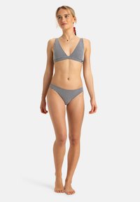 Černo-bílý kostičkovaný bikini s hlubokým V-výstřihem a nízkým pasem, s texturovanou tkaninou a minimálními kovovými akcenty.