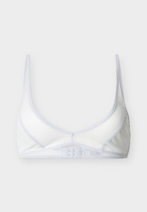 Άσπρο σουτιέν με μαλακά ποτήρια, λεπτές ρυθμιζόμενες τιράντες, διακριτική υφή με μικρές βούλες και κλείσιμο στην πλάτη με τρία αγκράφια, πάνω σε απλό ανοιχτό φόντο.