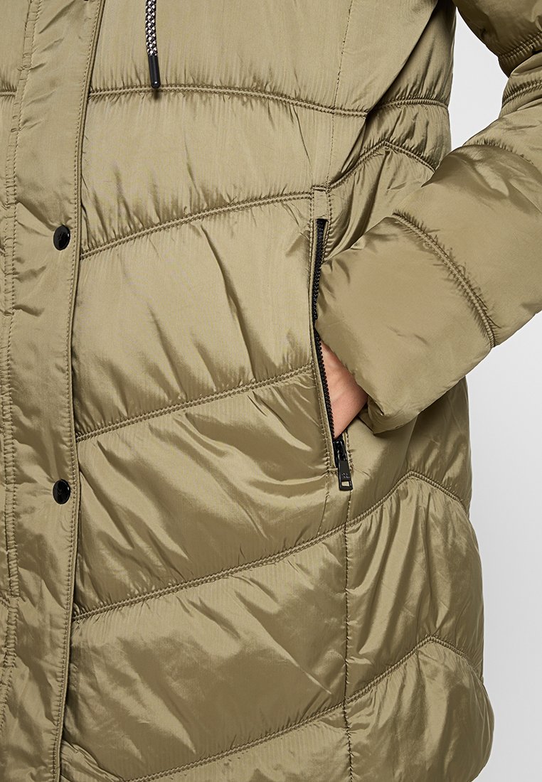 Giacca imbottita verde oliva con trapuntatura, tasche con zip e chiusura con zip. Presenta una texture liscia e lucida con dettagli di cucitura a contrasto.
