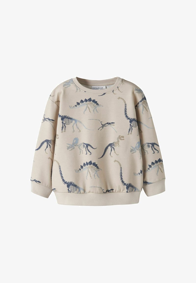 Sweat-shirt beige pour enfant avec imprimés de squelettes de dinosaures bleus et gris, poignets côtelés et col rond.