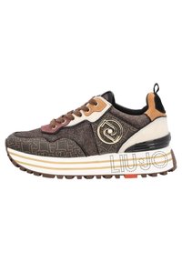 Sneaker avec un mélange de matériaux marron et beige, tissu texturé, accents dorés, détail de logo et une épaisse semelle blanche et marron avec des rayures.