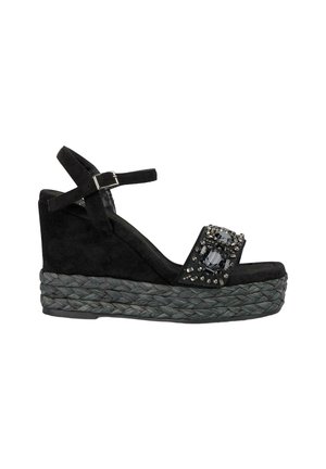 Sandalo con zeppa in suede nero, dotato di una piattaforma in juta intrecciata, con una fascia decorata con strass e una fibbia regolabile alla caviglia.