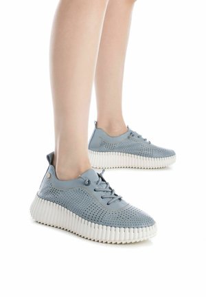 Zapatillas perforadas de color azul claro con suelas de goma blanca redondeadas, que presentan un diseño de cordones y sutiles detalles de costura.