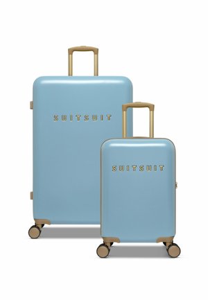 Twee koffers met een glanzende lichtblauwe buitenkant, gouden accenten en trekhandvatten. De grotere koffer staat achter de kleinere, beide op wielen.