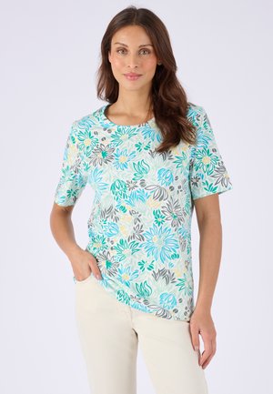 Bloes met korte mouwen en bloemmotief in turquoise, groen, geel en grijs op een lichte achtergrond; ronde halslijn en losse pasvorm.