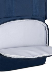 Zaino in tessuto blu navy con un interno liscio e foderato di bianco. Presenta una chiusura con zip e robuste cinghie superiori per il trasporto.