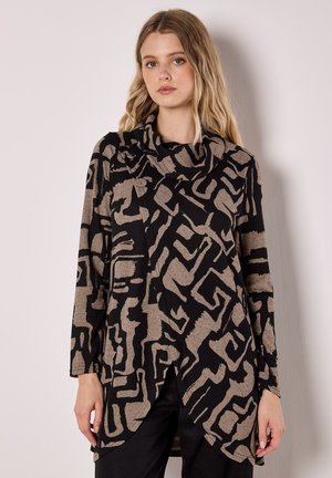 Maglietta a maniche lunghe nera e beige, con un motivo astratto, scollatura a cappuccio e design drappeggiato con aperture laterali. Tessuto morbido.