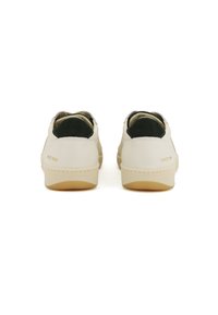 Sneakers in pelle beige con una parte posteriore texturizzata in verde scuro. Suola in gomma e "SINCE 1936" impresso sul tallone.