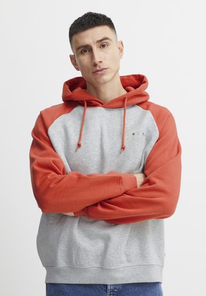 Hooded sweatshirt with a gray body and red sleeves, featuring a drawstring, ribbed cuffs, and a small logo on the chest.