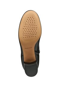 Suela de zapato de cuero negro con una parte inferior de goma marrón texturizada, que presenta patrones circulares y un detalle de marca en el talón.