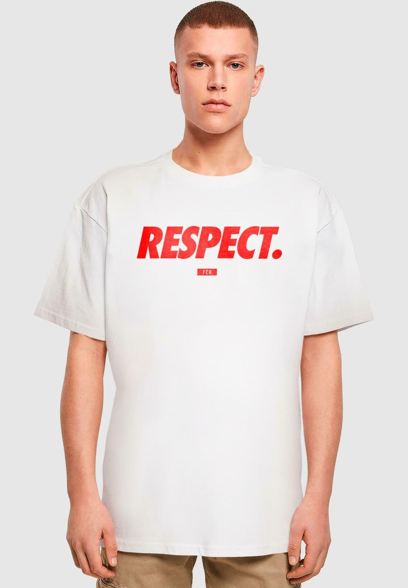 Camiseta blanca de gran tamaño con texto rojo en negrita que dice "RESPETO." y un pequeño logo debajo. Diseño de mangas cortas y cuello redondo.