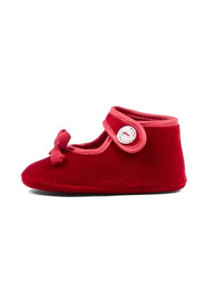 Zapato rojo para bebé con correa y cierre de botón, decorado con un lazo de tela en la parte delantera, suela blanda, vista lateral sobre fondo blanco.