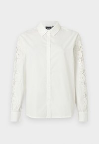 Λευκό πουκάμισο με κουμπιά, γιακά στο λαιμό, μακριά μανίκια με περίτεχνα δαντελένια διακοσμητικά στοιχεία και ομαλή βαμβακερή υφή.