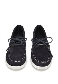 Scarpe da barca in camoscio blu navy con cuciture bianche, punta rotonda e lacci coordinati; presentano una superficie testurizzata e suola in gomma.
