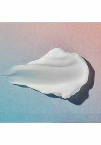 Hvid creme eller lotionstribe på en gradient baggrund. Teksturen virker glat med en blank finish og subtile skygger.