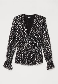 Blouse noire à manches longues avec motifs en forme de cœurs argentés, col en V profond, taille cintrée et poignets à volants.